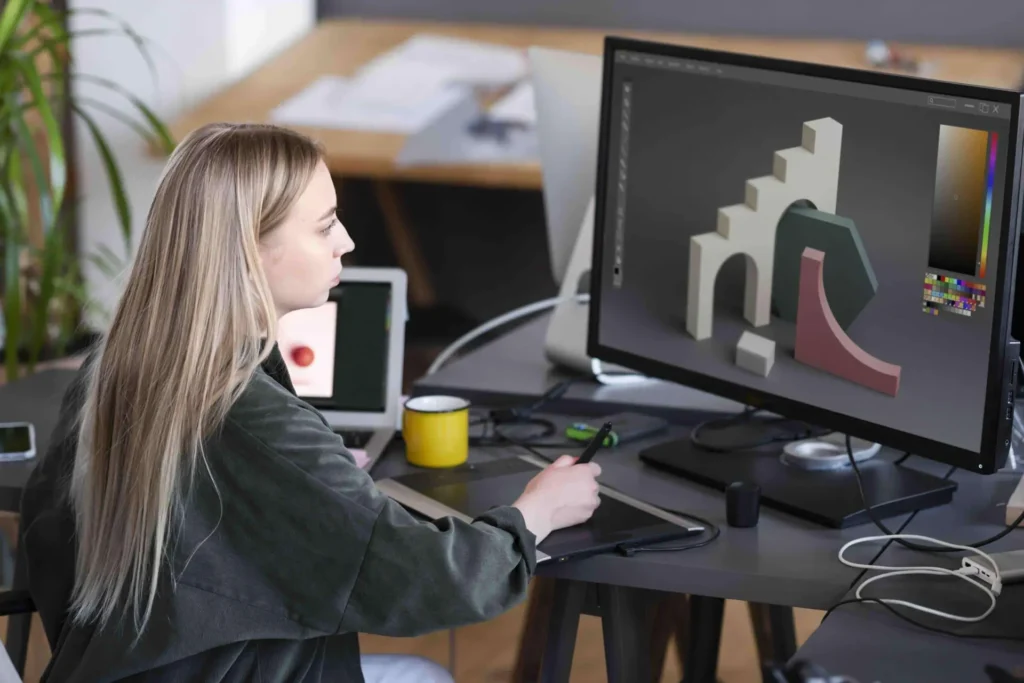 Woman working on a computer, focused on creating a 3D animation model