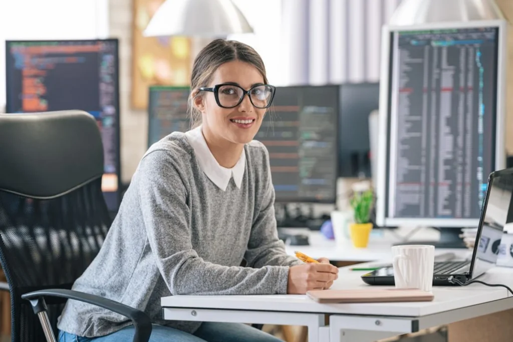 Woman works at a desk with a laptop, engaged in IT management tasks