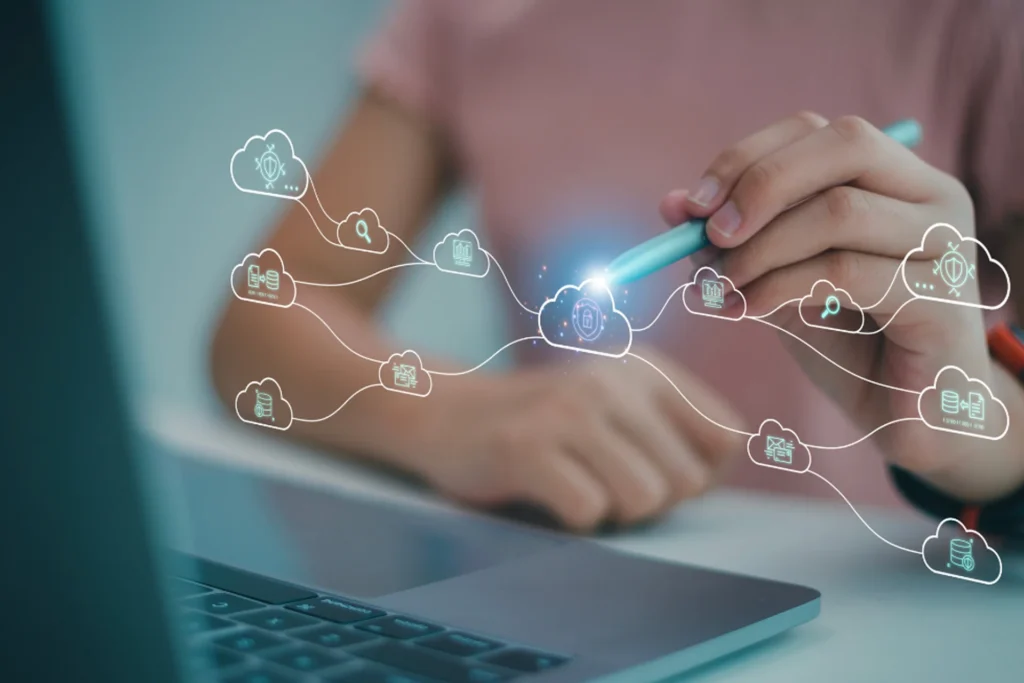 A hand writing on a laptop screen, representing cloud computing and tailored solutions for various industries