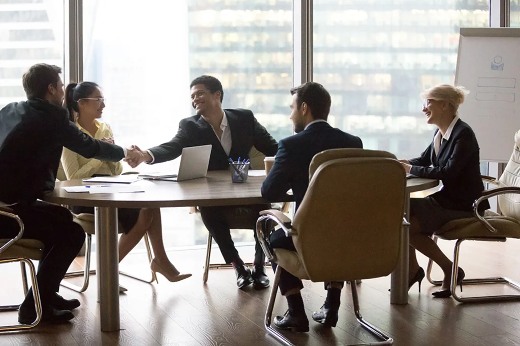 Group of diverse business professionals engaged in discussion around a conference table