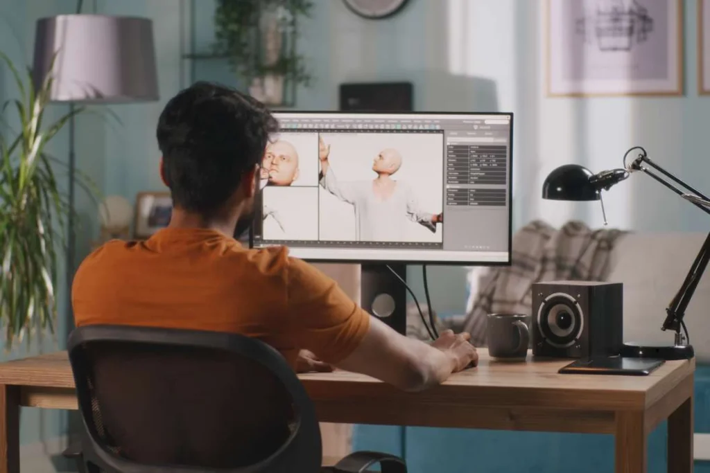 Man at a desk works on a computer, exploring the real-world impact of 3D animation through his screen