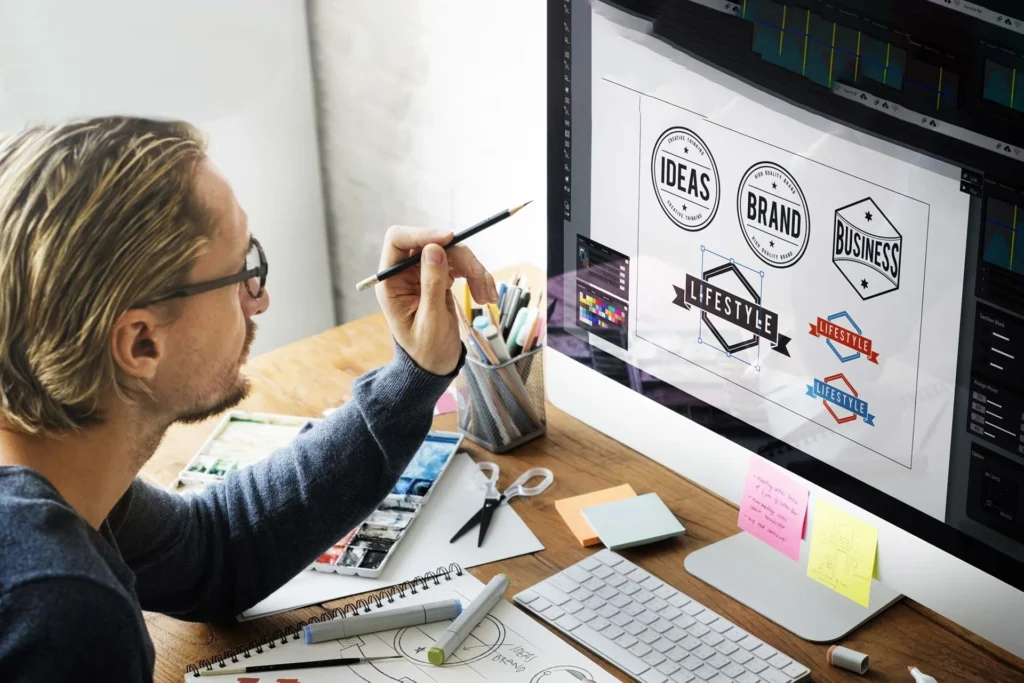 Man working on a computer displaying a logo for logo design services