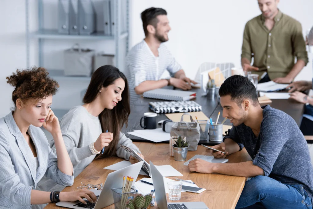 Team of people working together at a table with laptops, exploring technology solutions tailored for non-profits