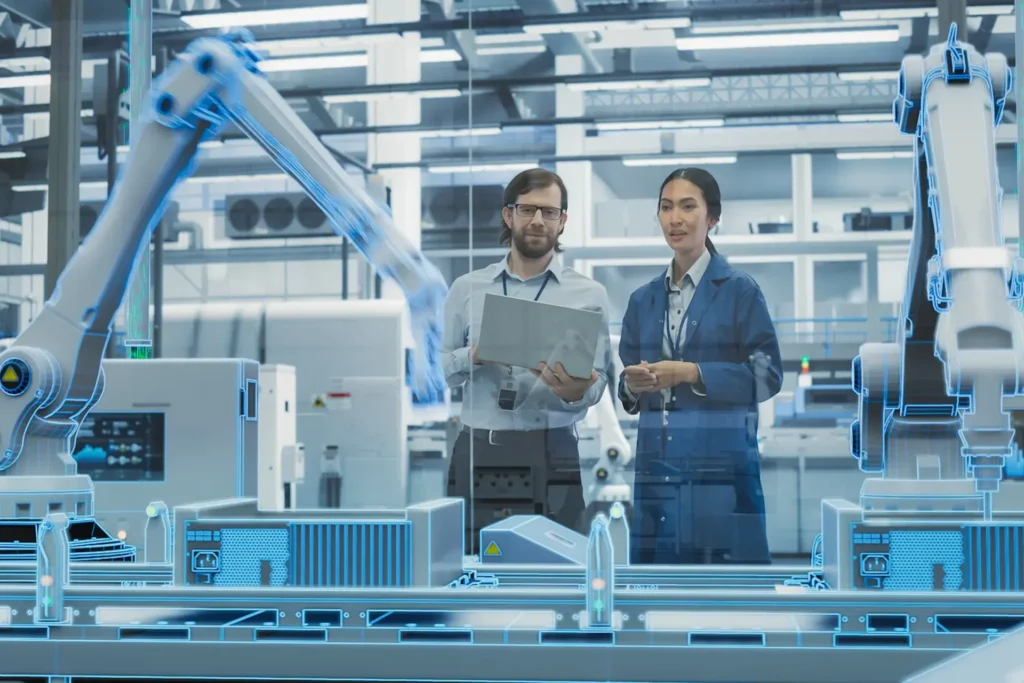 Two individuals operating in an industrial area, with robots assisting in a smart factory automation process