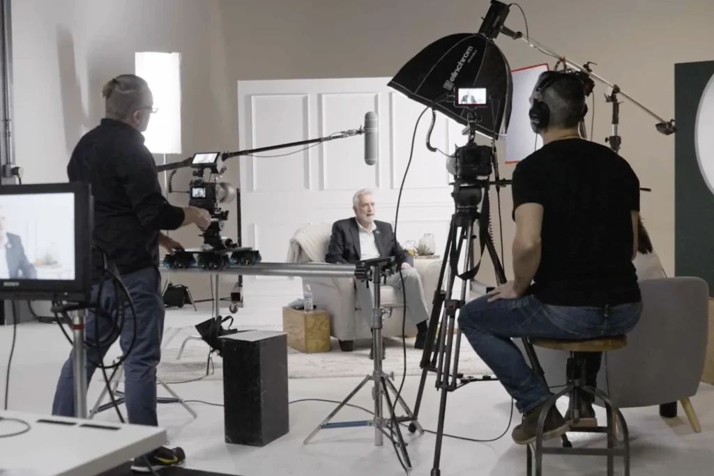 A man operates a camera in a studio, showcasing multimedia solutions to enhance video production